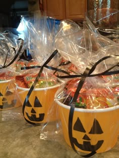 plastic cups filled with candy and decorated as jack - o'- lantern pumpkins