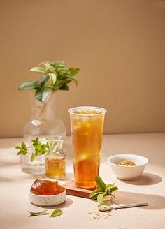 there are two cups with drinks on the table next to each other, one is filled with tea