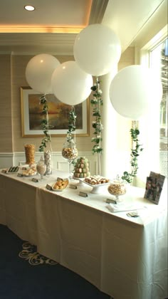 a table with balloons and desserts on it