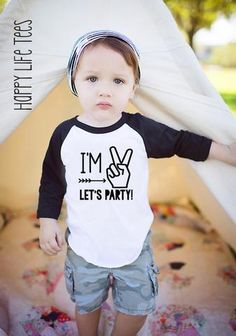 a little boy standing in front of a teepee with the words i'm let's party written on it