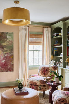 a living room filled with furniture and a painting on the wall