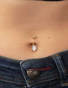 a woman's stomach with two piercings attached to the side of her belly