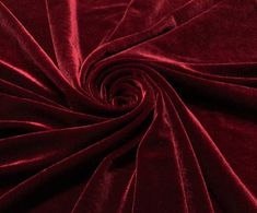 a close up view of a red velvet fabric with very thin lines and folds in the center