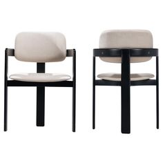 two black and white chairs with beige upholstered backrests are facing each other