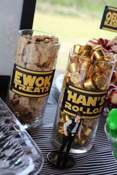 a table topped with two cups filled with candy and candies next to each other