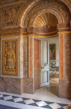 an ornate hallway with paintings on the walls and marble flooring in front of it