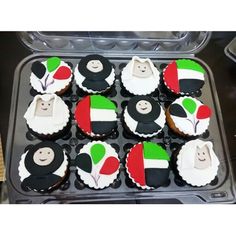 cupcakes decorated in the shape of animals are sitting on a plastic tray with black, white and green frosting