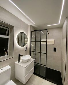 a bathroom with a sink, toilet and shower stall in the middle of the room