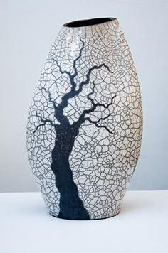 a black and white vase with a tree on it