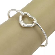 Material: sterling silver Hallmark: Tiffany & Co. Peretti 925 Spain Measurement: inner circumference: 6.5" x 0.10" thick Heart: 0.77" tall x 0.84" wide x 0.16" thick Weight: 13.4 grams  This authentic bangle is from Tiffany & Co. by designer Elsa Peretti from her Open Heart collection. It is crafted from sterling silver with a 2.5mm thick wire bangle, the front has the contour open heart with a 2 points diamond at the top of the heart. One end of the bangle has a small curved hook which and secu Luxury Sterling Silver Heart Bracelet For Anniversary, Luxury Sterling Silver Bracelets For Valentine's Day, Luxury Sterling Silver Heart Bracelet For Valentine's Day, Modern Sterling Silver Jewelry For Valentine's Day, Sterling Silver Bangle With Heart Charm, Sterling Silver Clasp Bracelet For Valentine's Day Anniversary, Elegant Double Heart Sterling Silver Bracelet, Elegant Adjustable Sterling Silver Heart Bracelet, Anniversary Sterling Silver Bangle With Silver Clasp