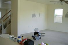 an empty living room with paint and other items on the floor in front of it