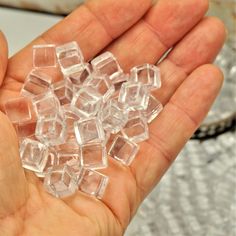 a person holding some clear cubes in their hand