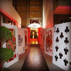 several playing cards are lined up in front of a casino sign and entrance to the building