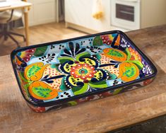 a colorful tray sitting on top of a wooden table next to a stovetop oven