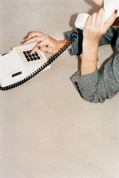 a woman holding a phone up to her ear and using it as a cordless telephone