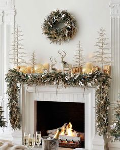 a fireplace decorated for christmas with candles and greenery