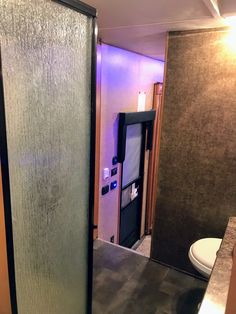 a bathroom with a glass shower door next to a toilet