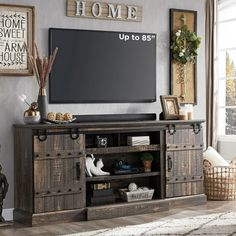 a living room with a large flat screen tv on top of a wooden entertainment center