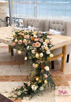 a table with flowers on it in front of a couch