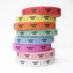 multicolored admit tickets stacked on top of each other with the words admit one printed on them