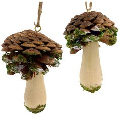 two pine cone shaped ornaments hanging from strings