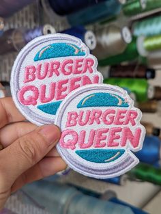 two burger queen patches are shown in front of some sewing supplies