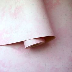 a roll of pink paper sitting on top of a white wallpaper covered in stars