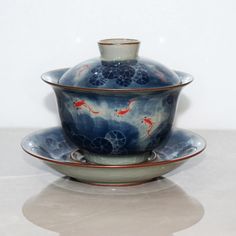 a bowl and saucer sitting on top of each other in front of a white wall