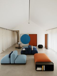 a living room filled with furniture next to a white curtained wall and flooring