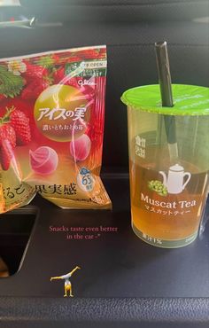 a plastic cup with strawberries in it next to a bag of macaroni tea