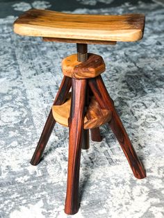 a wooden stool sitting on top of a carpeted floor