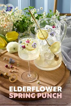 the elderflower spring punch is ready to be served in glasses with flowers and gold spoons