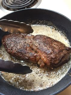 steak being cooked in a skillet on the stove