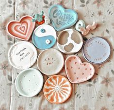 there are many small ceramic plates on the table with words and hearts around them,