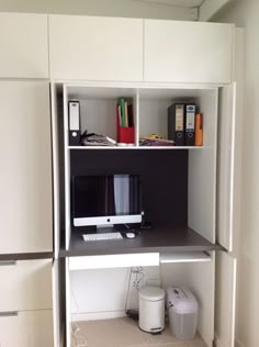 a white desk with a computer monitor and keyboard on it's shelf next to other office supplies