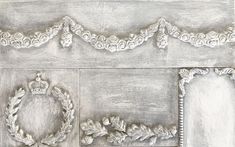 an image of a white wall with some ornaments on it and a crown in the middle