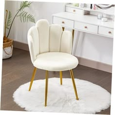 a white chair sitting on top of a wooden floor next to a table and mirror