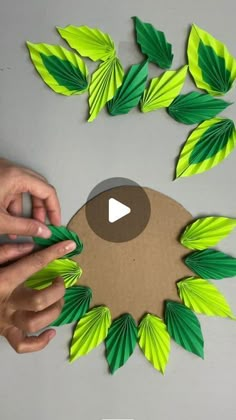 someone is cutting out some paper leaves with scissors