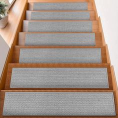 a set of stairs with carpeted treads on each side and plant in the middle