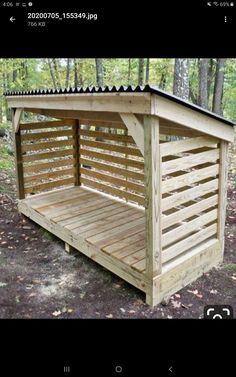 a small wooden shelter in the woods