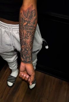 a man with a tattoo on his arm holding the hand of another person's leg