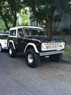 two black and white trucks parked on the street