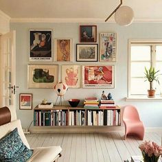 a living room filled with furniture and lots of pictures on the wall above it's bookshelf