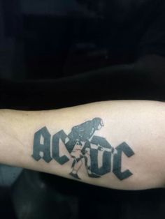 a man with a tattoo on his arm that reads ac dc and is holding a baseball bat