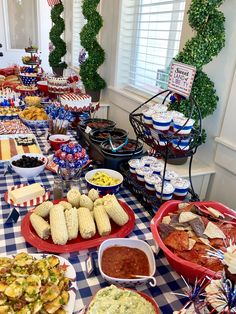 a table full of food and desserts with american flags on the table cloth in front of them