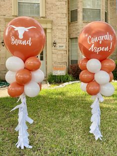 two balloons with the words, congratulations as seen on them in front of a house