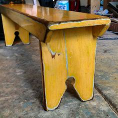 an old wooden bench sitting on top of a floor