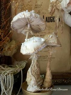 two mushrooms are sitting on a table next to pearls and flowers in front of a framed photograph