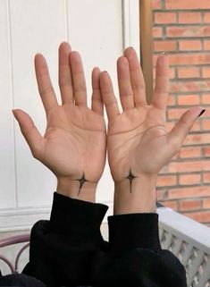 a woman with her hands in the air and two cross tattoos on their wrists