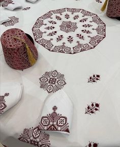 a table topped with white and red cloths covered in tasseled doily